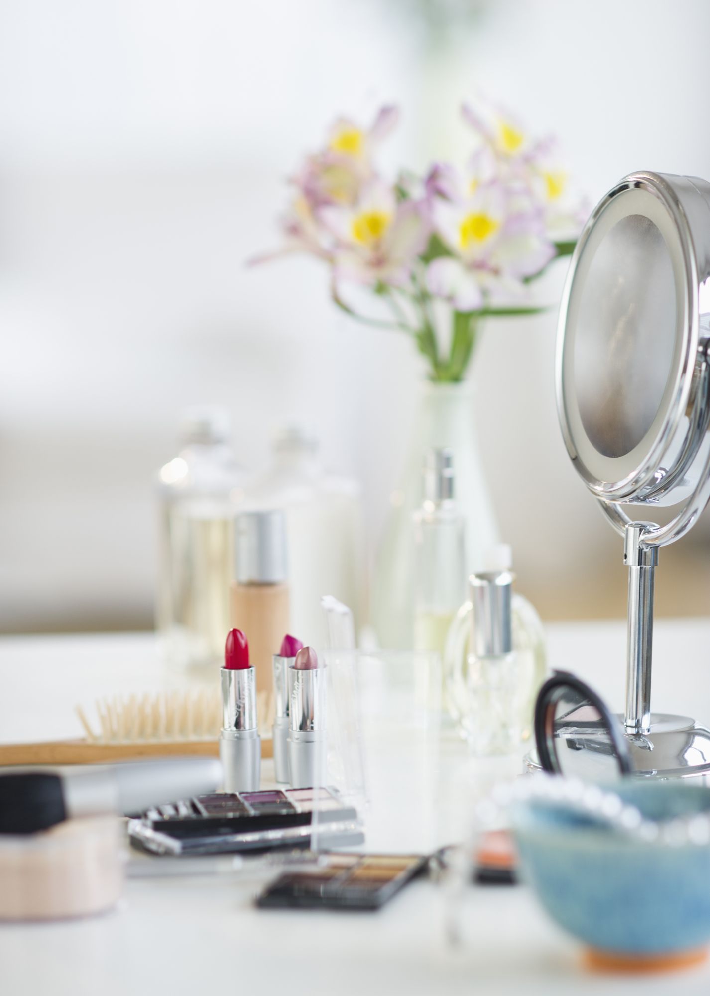 Makeup och skönhetsmedel med spegeln på den vita tabellen