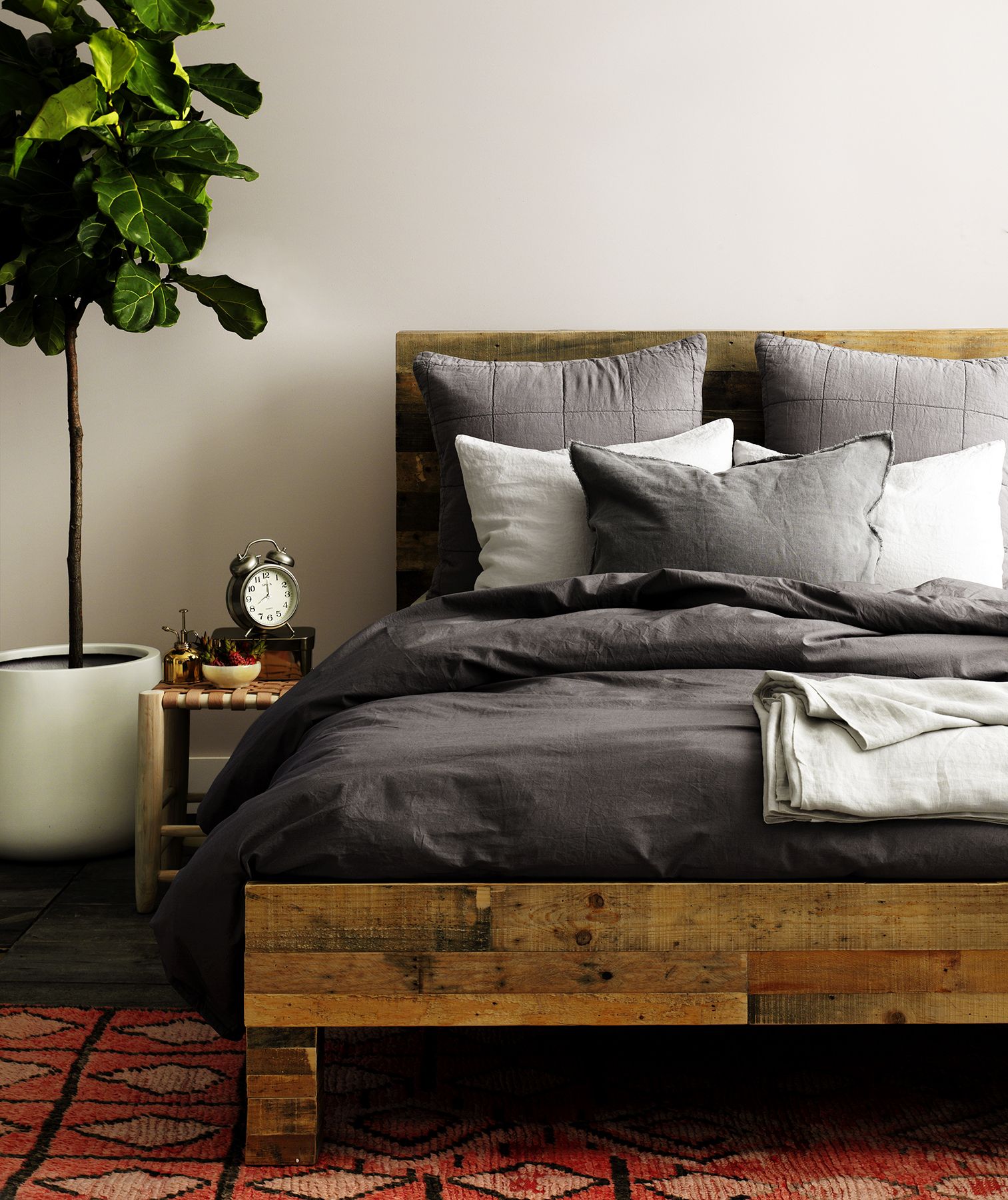 グレーの色合いのリネンと木製のベッド