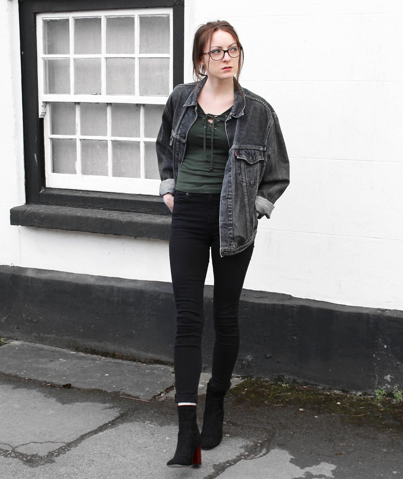 אישה לובשת מעיל ג'ינס משובץ וינטג 'עם תלבושת בצבע כהה