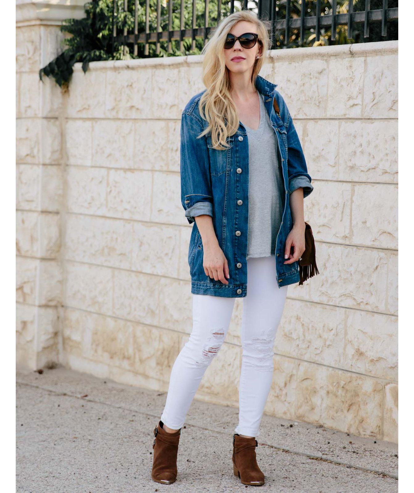 Kvinne iført overdimensjonert jeanjakke med hvite jeans