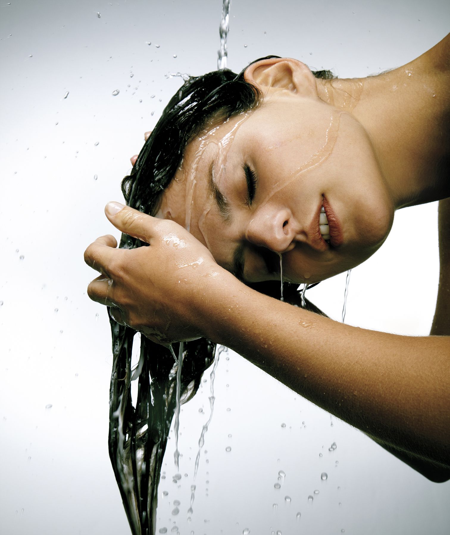 אישה שוטפת שיער במקלחת