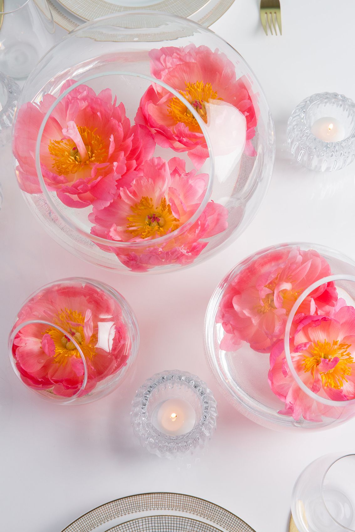 Rosa blomsterarrangemang i glasskålar