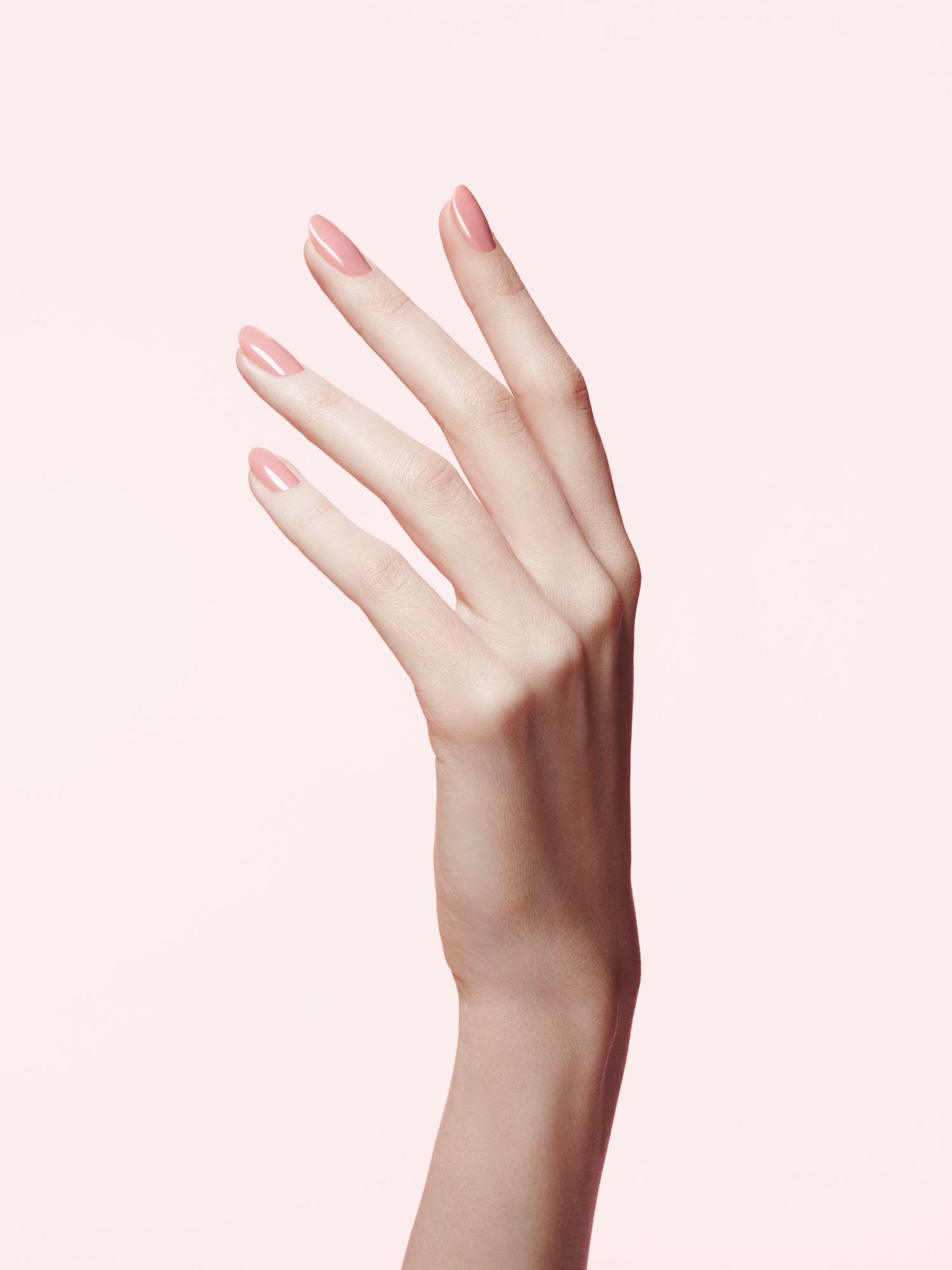 Hånd med lyserød gelmanicure