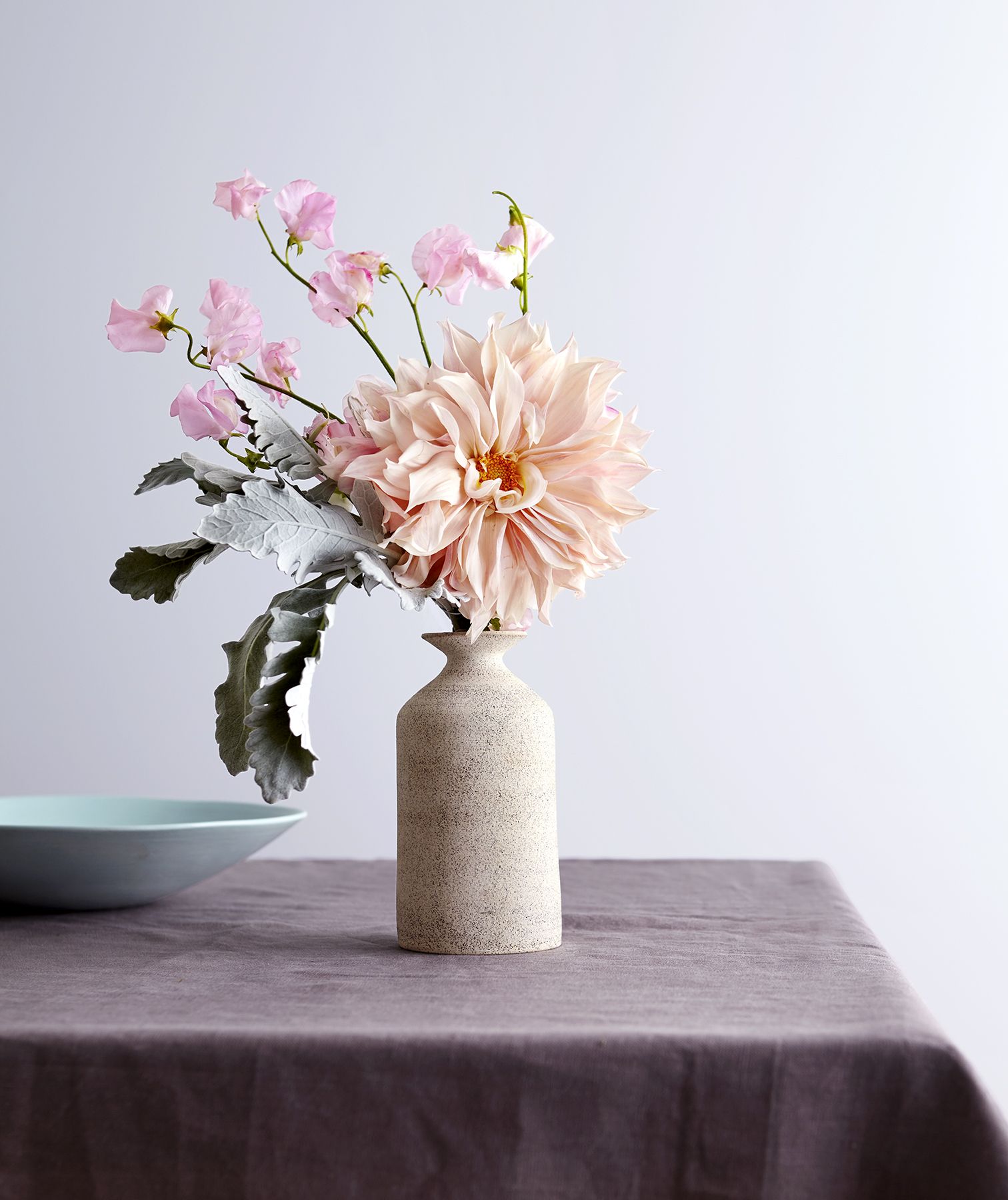Vase med blomster, blå bolle på bordet