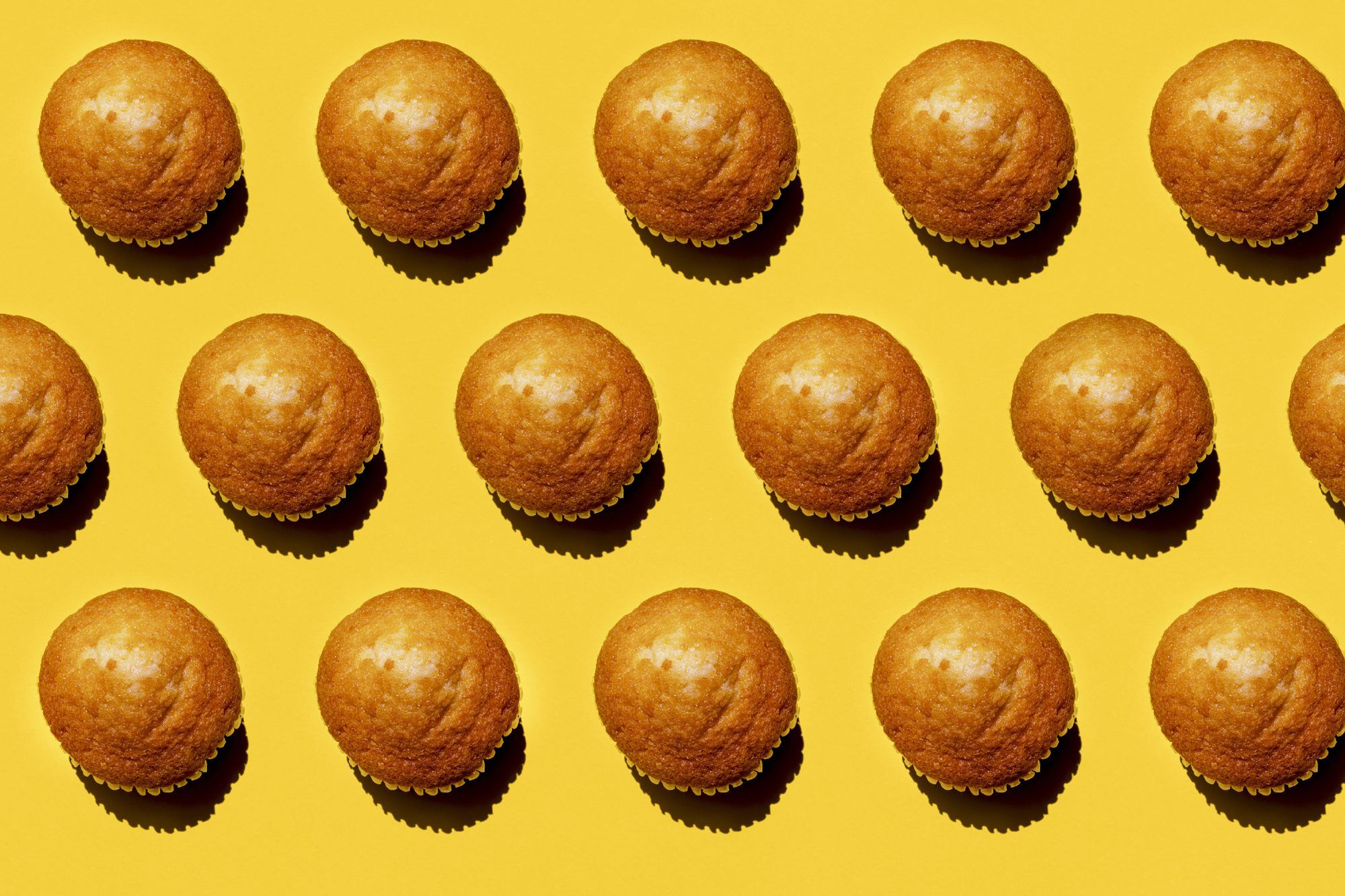Patroon van rijen muffins tegen gele achtergrond