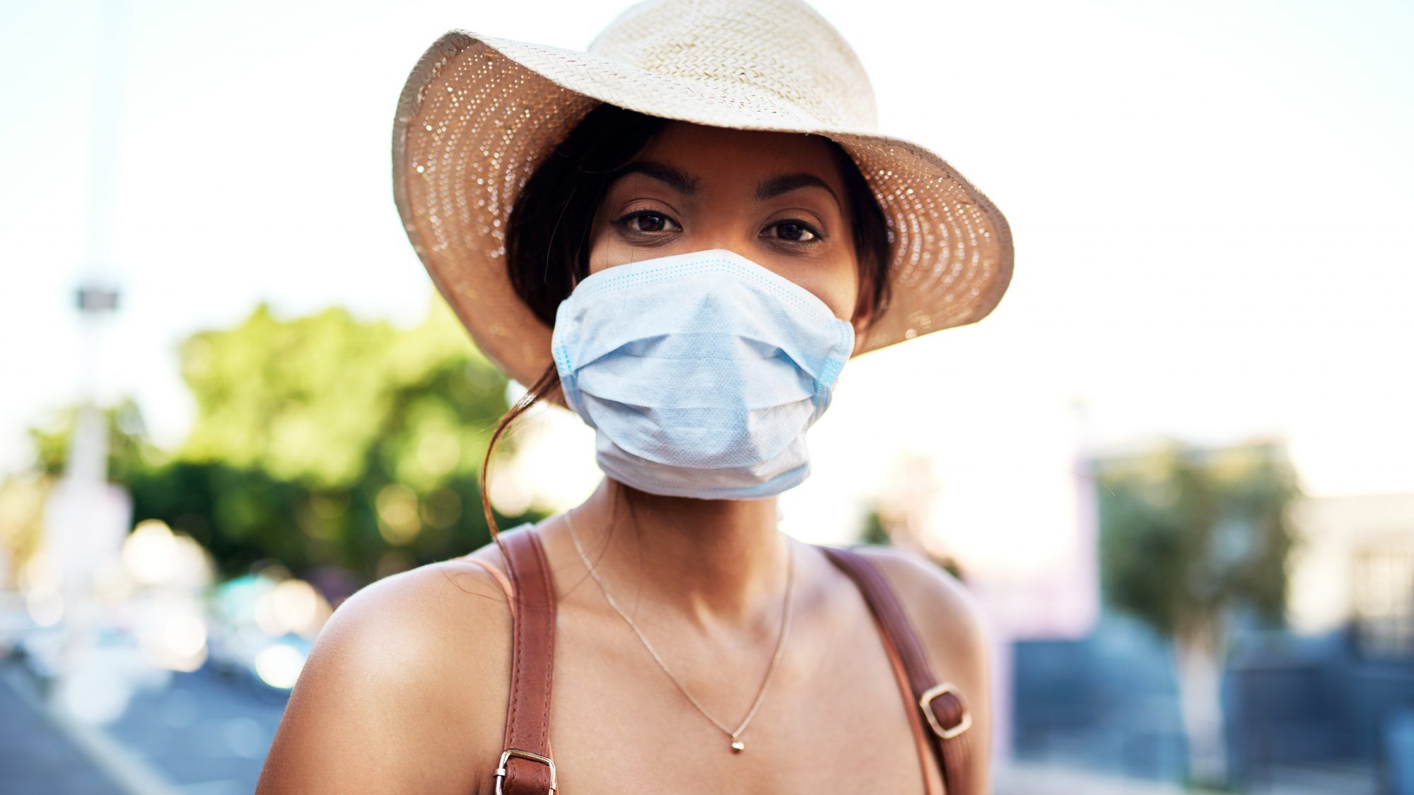 practici sigure-coronavirus: femeie cu mască de față și pălărie