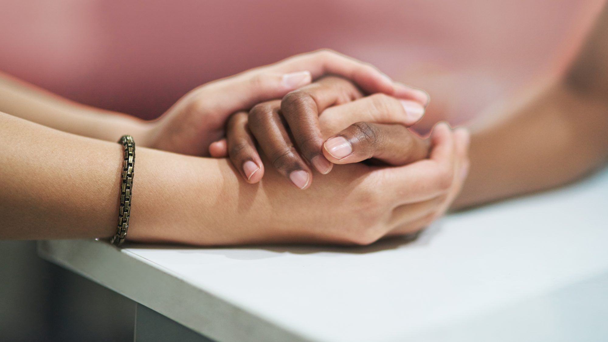 Fragen an Ihren Partner, um eine Beziehungsintimität aufzubauen: Nahaufnahme von zwei Personen, die Händchen halten