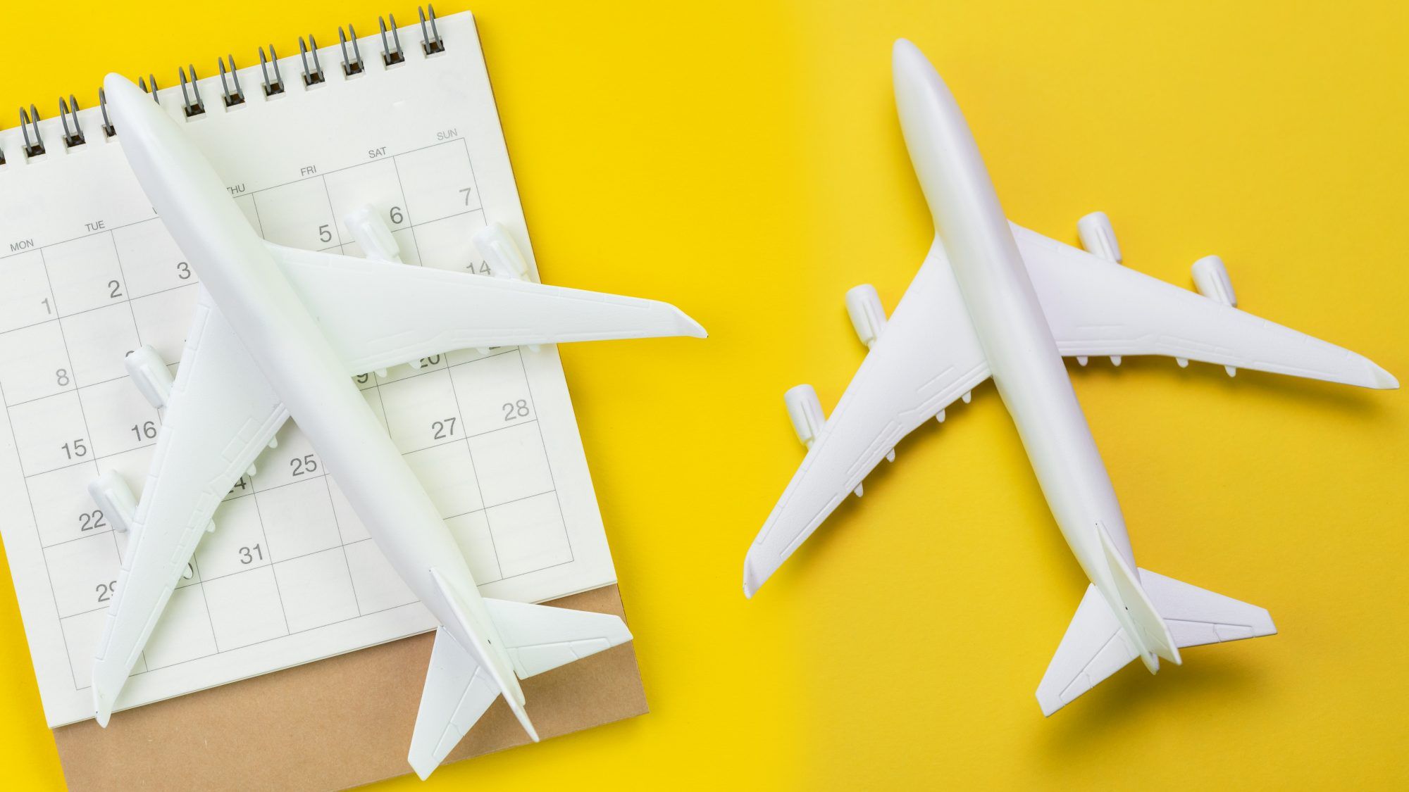 航空券を購入するのに最適な時期-フライトを購入するのに最適な時期、時期、曜日：カレンダー上のプラスチック飛行機